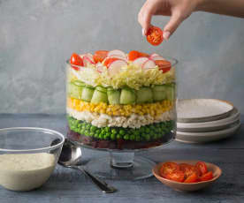 Layered vegetable salad with creamy herb dressing