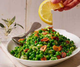 Erbsen und Frühlingszwiebeln in Olivenöl