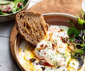 Turkse eieren (Cibir) op Griekse yoghurt, geserveerd met toast en groene salade