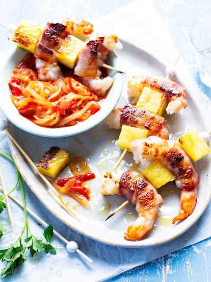 Brochetas de langostinos, beicon y piña con guarnición de verduras