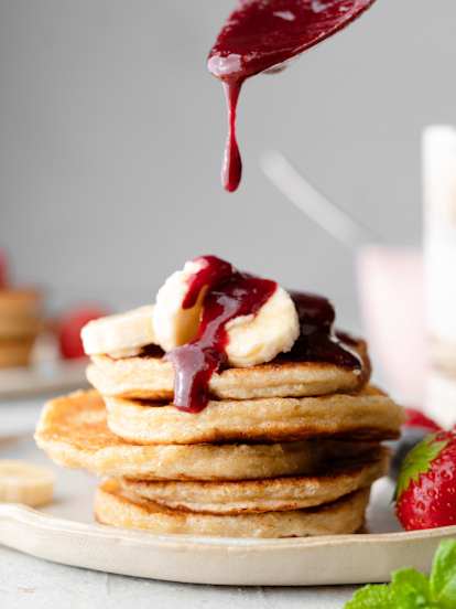 Pancakes de queso cottage con salsa de frutos rojos y plátano