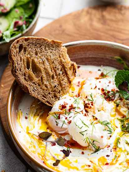 Huevos turcos servidos con tostadas y ensalada verde TM6 (Pelar)