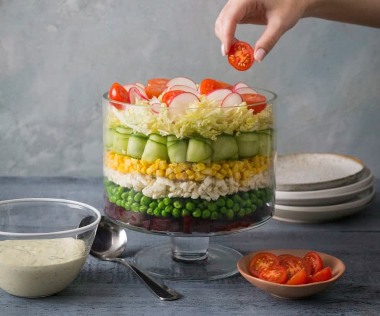 Layered vegetable salad with creamy herb dressing