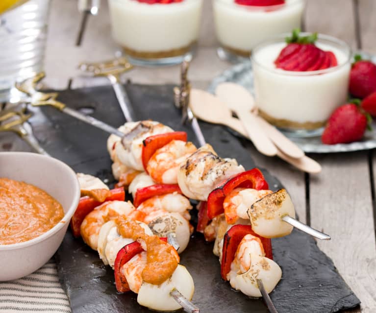 Brochetas de rape y langostinos con emulsión de escalivada. Vasitos de limón y fresas.