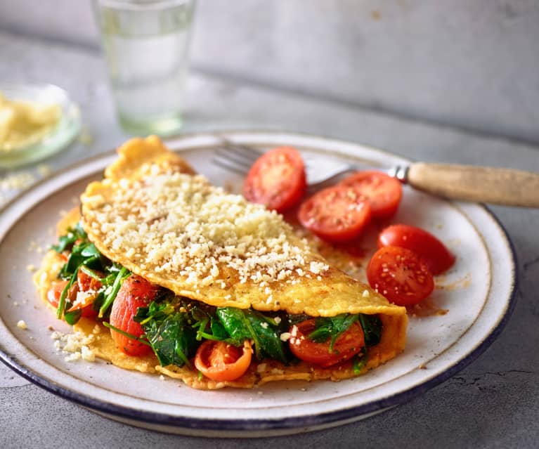 Tortilla francesa rellena de espinacas y queso con tomates cherry