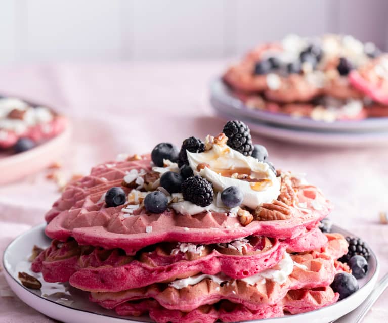 Waffles rosas con frutos rojos.