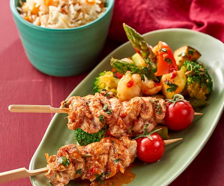 Chicken skewers with cumin rice and warm vegetable salad