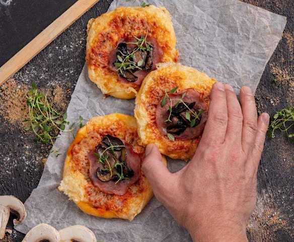 Pizzerinki z rumienionymi pieczarkami, serem tylżyckim i szynką