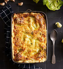 Lasanha verde de bacalhau com couves e béchamel de alho assado